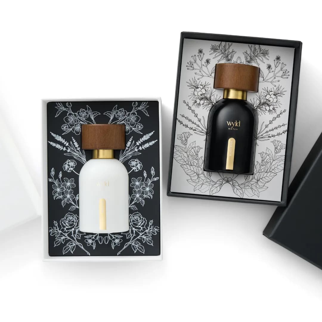 White Lie y Black Book en sus cajas de regalo con ilustraciones botánicas